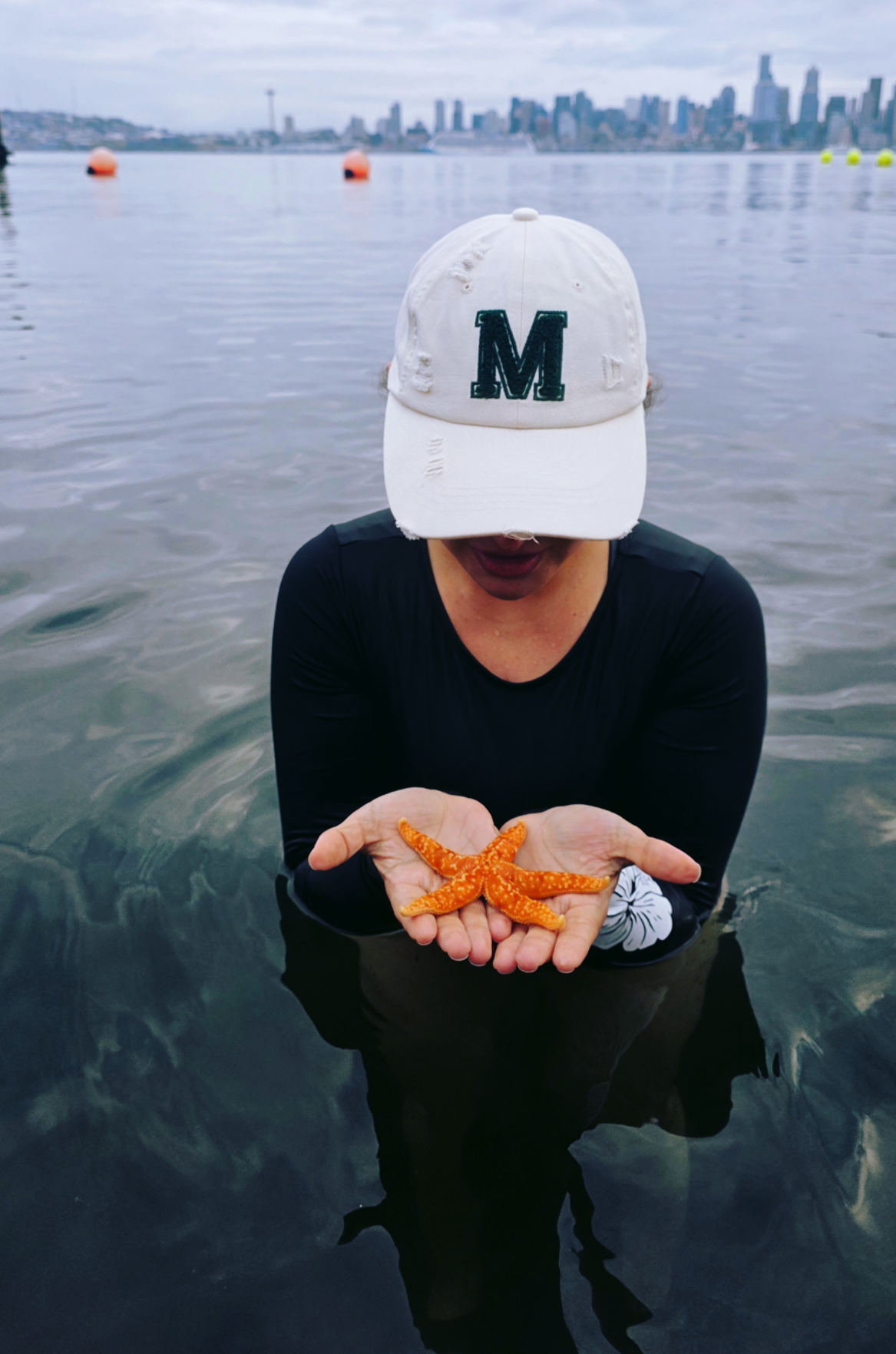 Mónika Jáuregui holding a starfish in Seattle waters